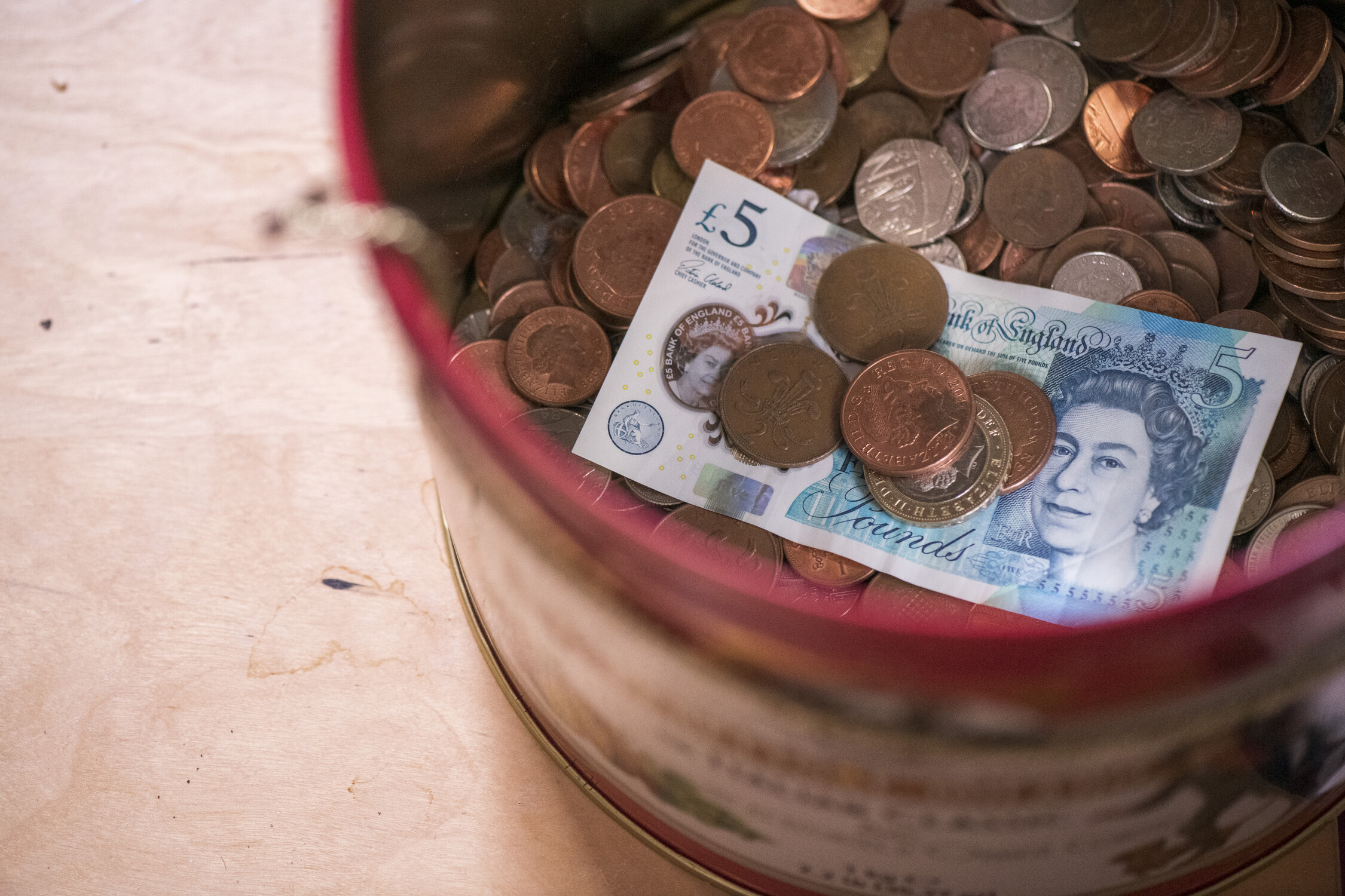 A basket on the floor filled with money.