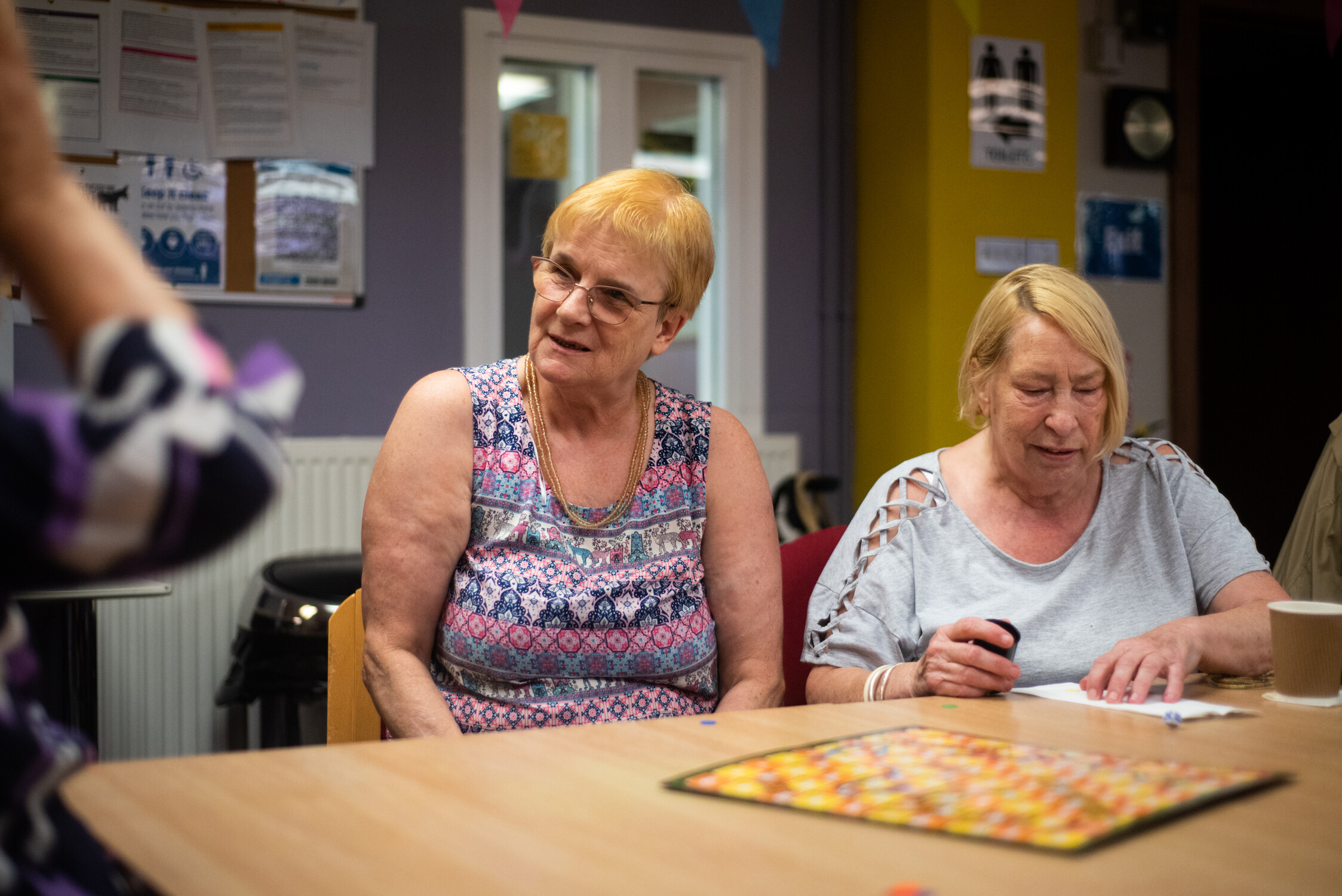 Two women in a community centre playing games together