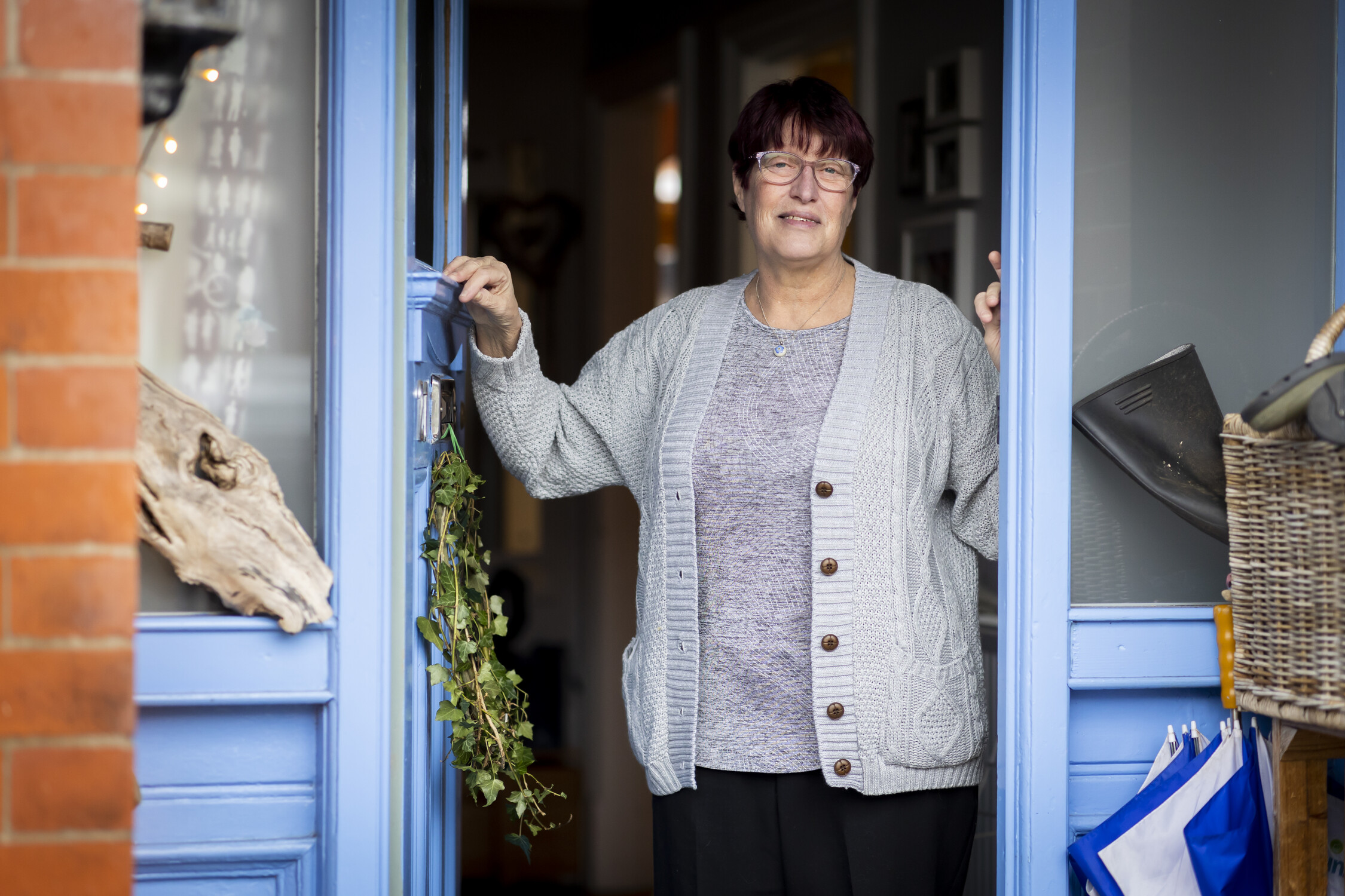 A woman is standing in her doorway smiling