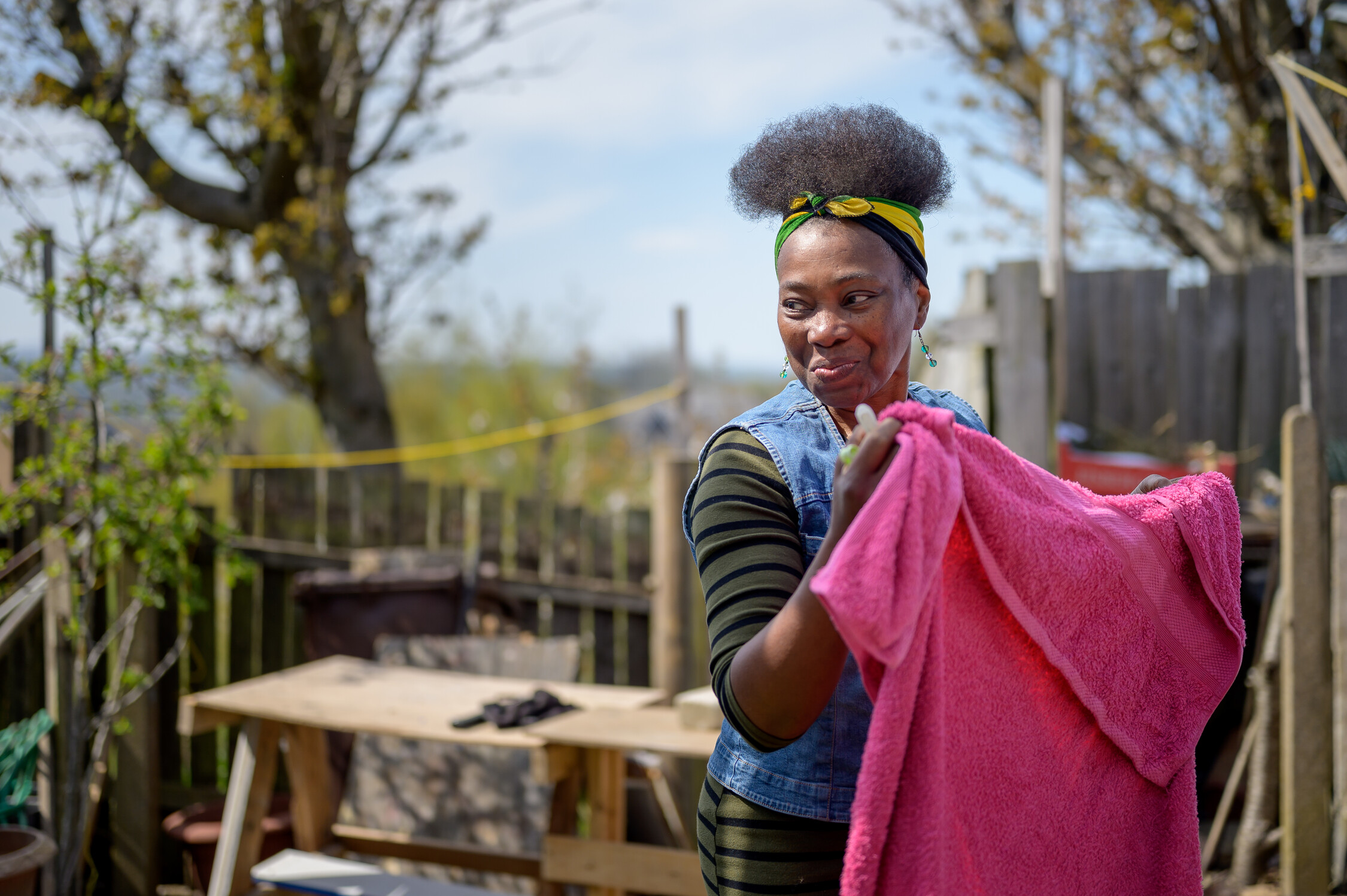 Woman in her garden putting laundry on the line.