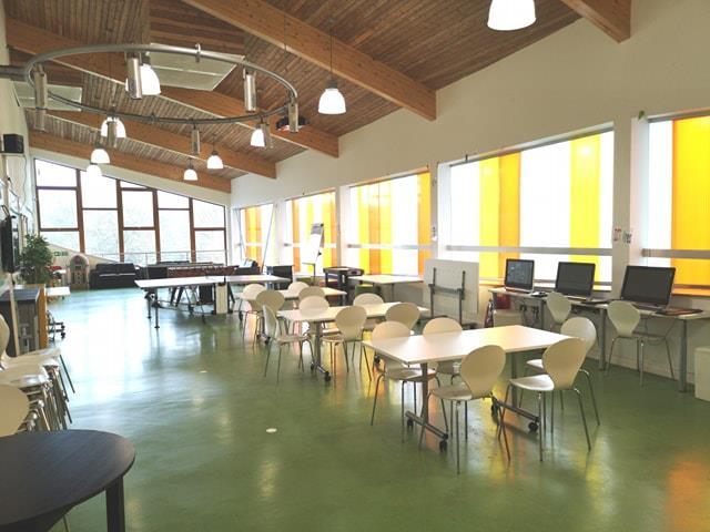 Large airy room with tables and chairs.