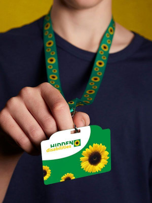 Person holding a sunflower-themed lanyard and card labeled “HIDDEN disabilities.”
