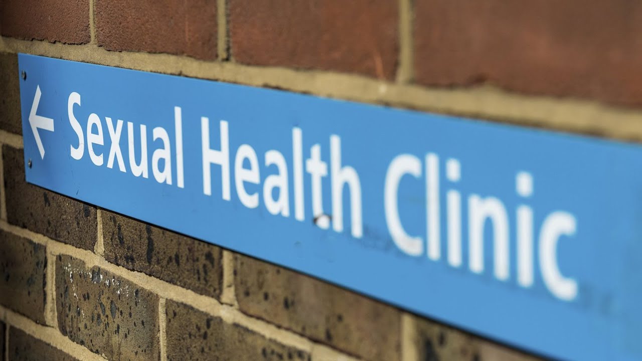 A brick wall with a sign on it saying 'sexual health clinic'