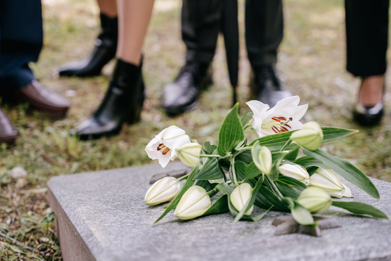 Flowers on top of a grave stone at a funeral
