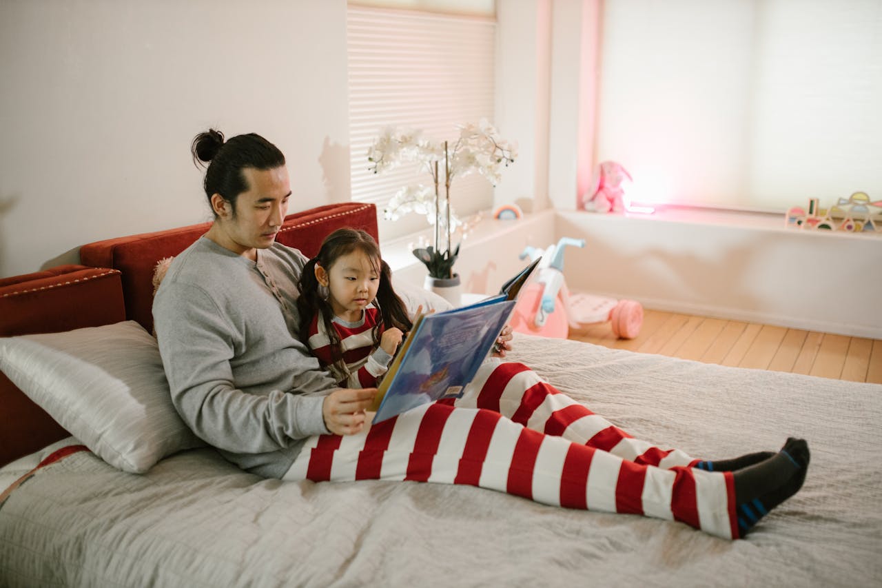 Reading before bed A dad sat with a young child reading before bed