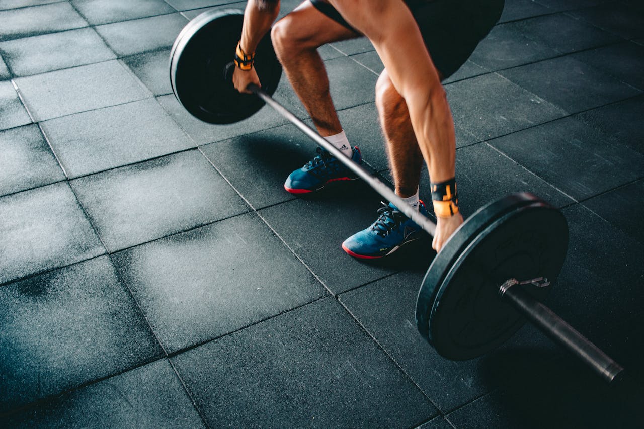 Person in a gym preparing to lift a barbell