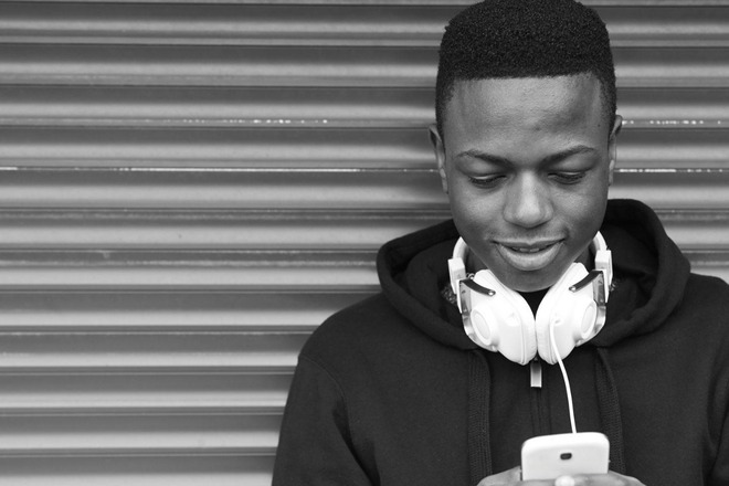 Young man smiling looking down at his phone