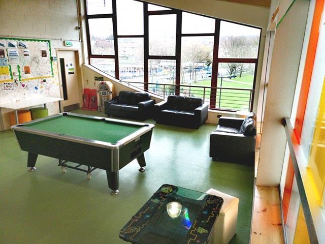 Games Room with a pool table and large windows looking out to a park.