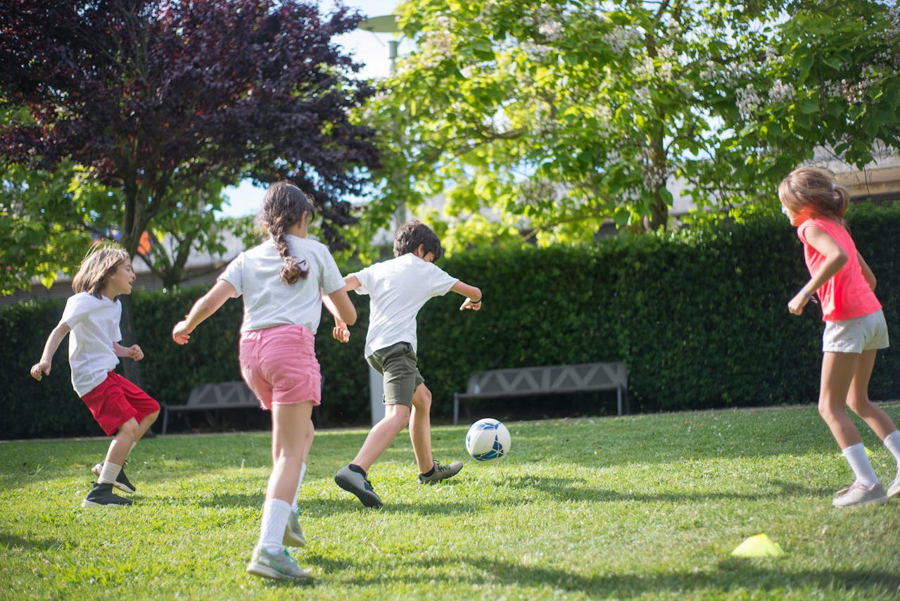 A group of children playing football in a garden.