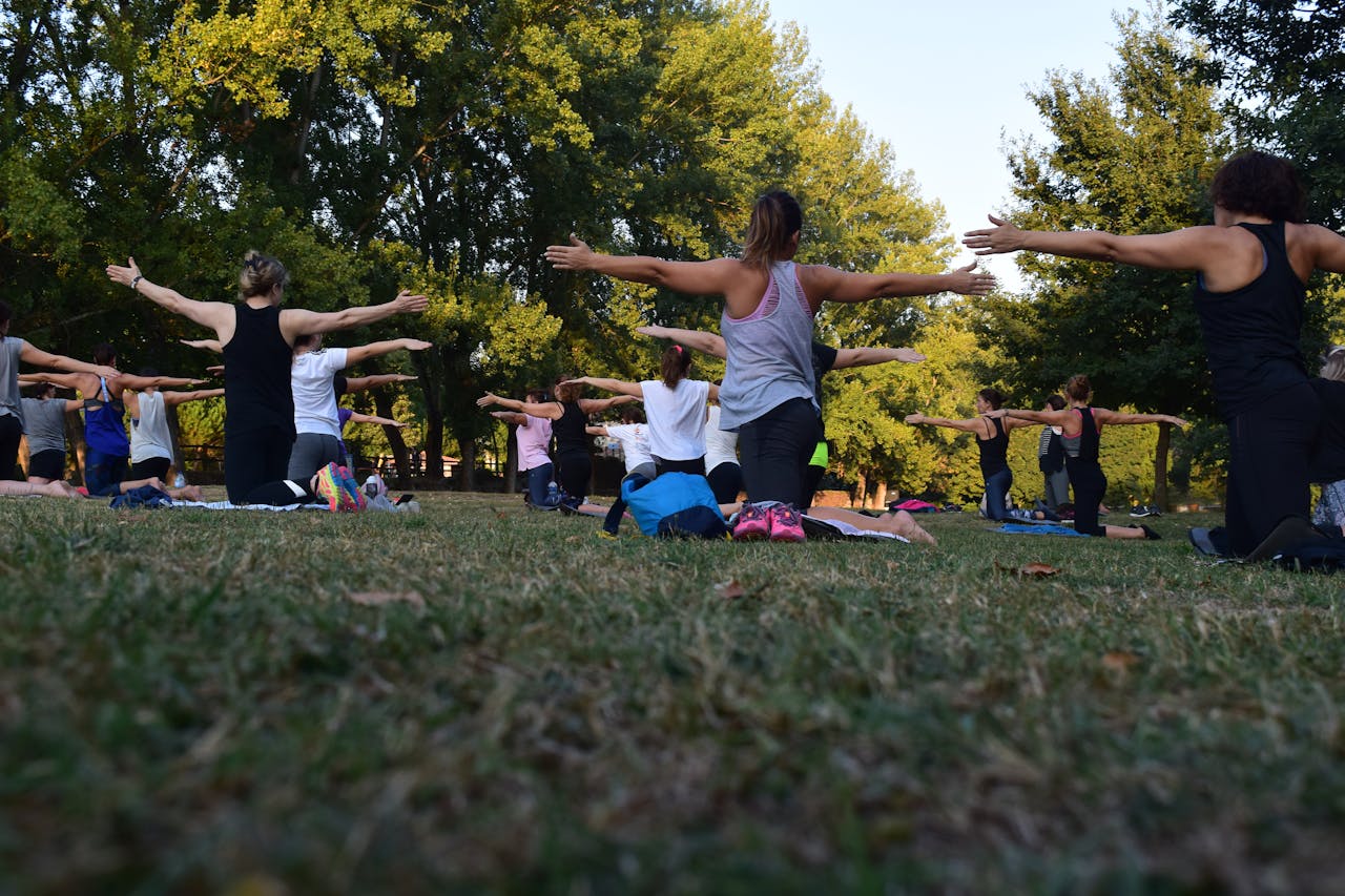 A group of people do yoga in the outdoors.