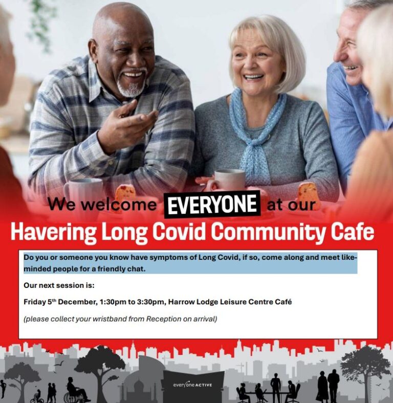 People sat around a table with a cup of tea smiling and talking with one another