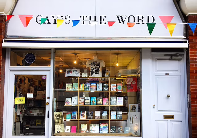 Gays the Word bookshop store front. The front of the shop is white and there is rainbow bunting in front. Lots of books are in the window.